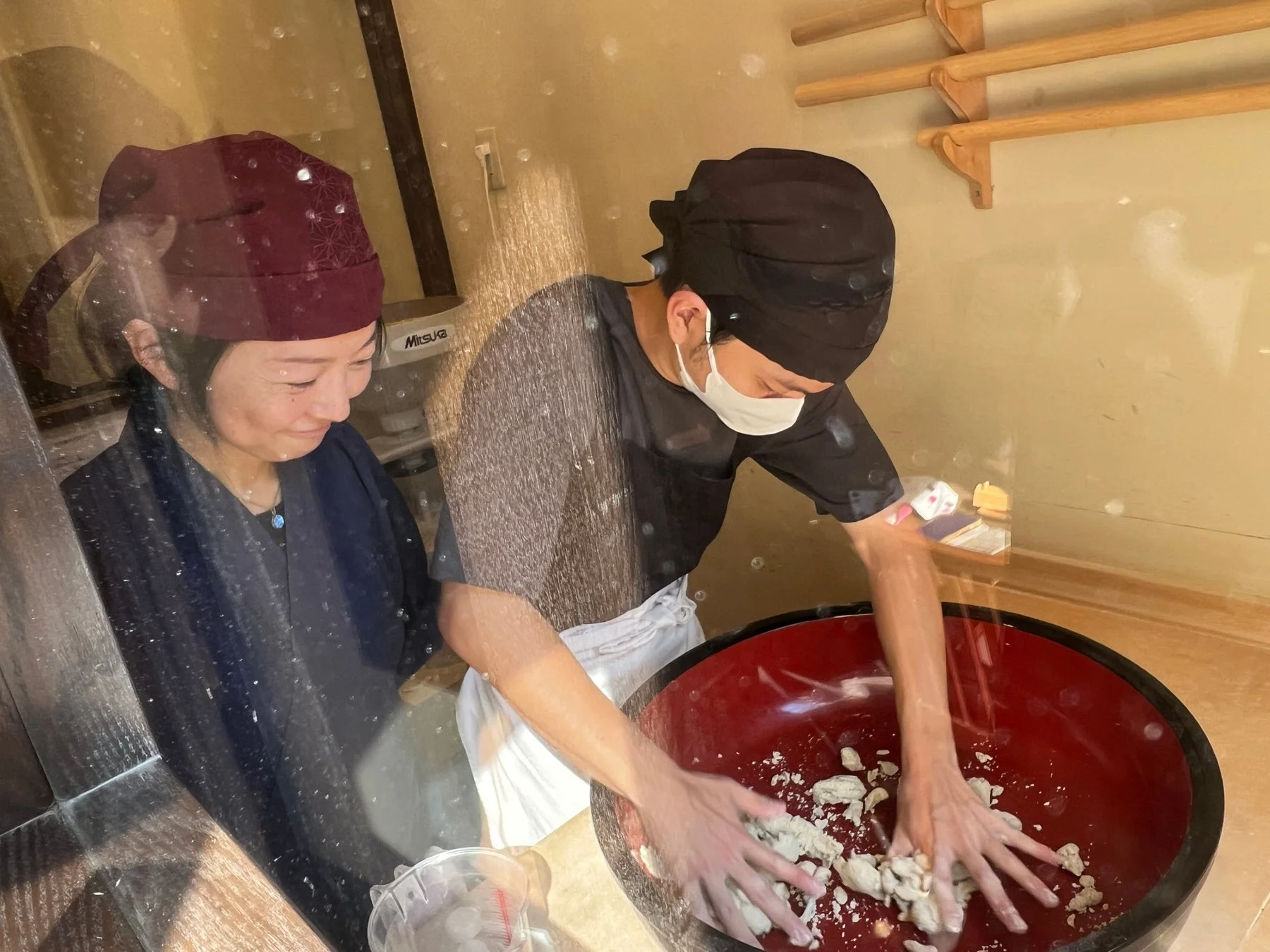 職人が大きなボウルで生地を捏ねる様子