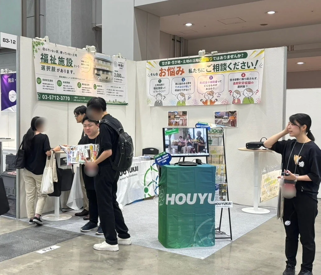 展示会ブースで説明を聞く来場者